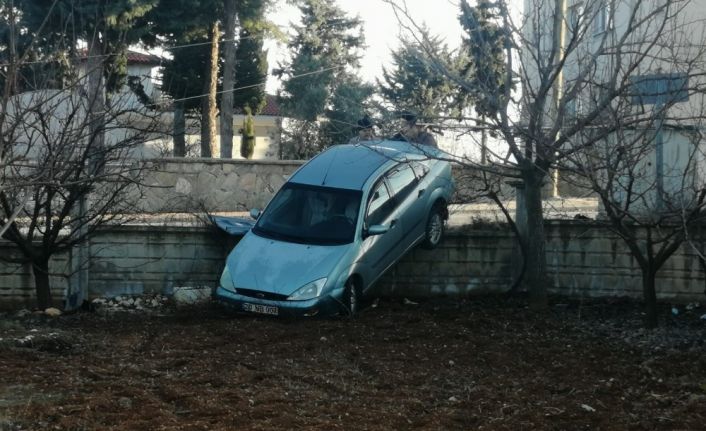 Otomobil bahçe duvarını aşıp askıda kaldı