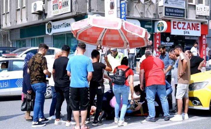 Yerde yatan yaralıyı şemsiye ile güneşten korudu