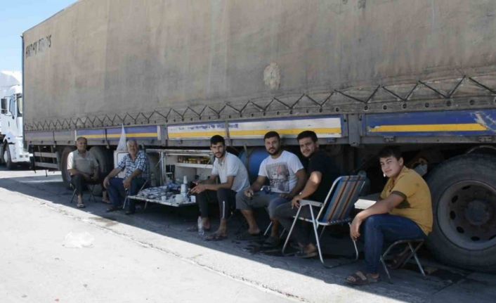 Şırnak’ta tır parkında bekleyen şoförler araçlarının gölgesinde serinliyor