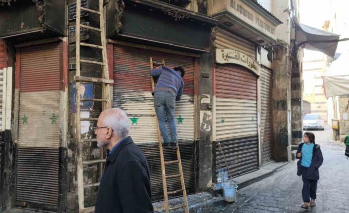 Esnaflar kepenklerindeki eski Suriye bayraklarını kazımaya başladı