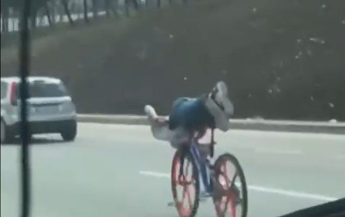 Bisikletin üzerinde uzanarak giden gençler trafiği tehlikeye attı