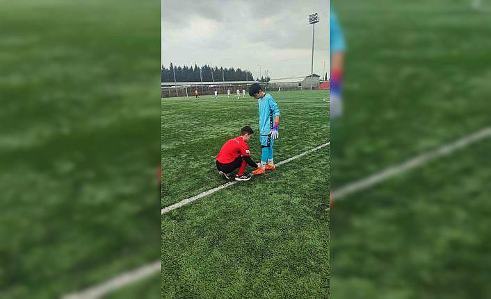 Hakem futbolcunun kramponlarını bağladı